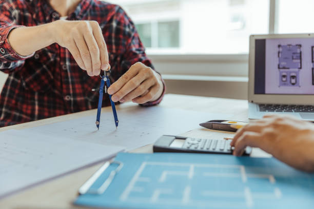 istock Architect designing house examining house plans Customer assigned project and custom designs before delivery. interior design and decoration ideas 1488778413