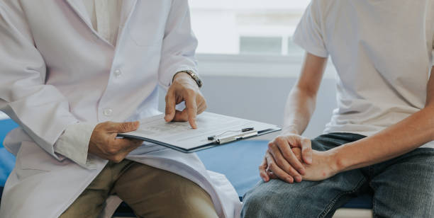 male health concepts. the young man with pain consulted a doctor for treatment. the doctor is interviewing and advising the patients. - sexual issues imagens e fotografias de stock