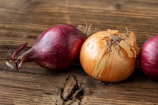 istock Yellow and red onions on a wooden board 1488783020