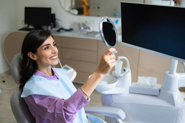istock Happy woman looking at her white teeth at the dentists'. 1488785084