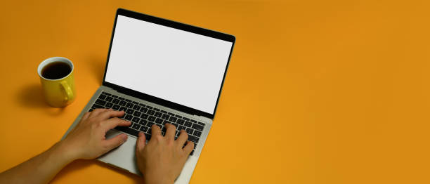 istock Shot from above view of unrecognizable hands typing on keyboard of laptop computer over yellow background. 1488785367