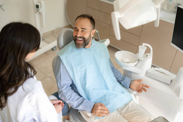 診療所で歯科医と話す幸せな男性患者。 - caucasian cavity clinic color image ストックフォトと画像