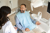 Happy male patient talking to his dentist in medical clinic.