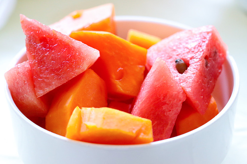 Stock photo showing a healthy eating breakfast fruit bowl of juicy, ripe sliced watermelon and fresh papaya. Fruit salad breakfast buffet, with healthy fruit and vegetables.