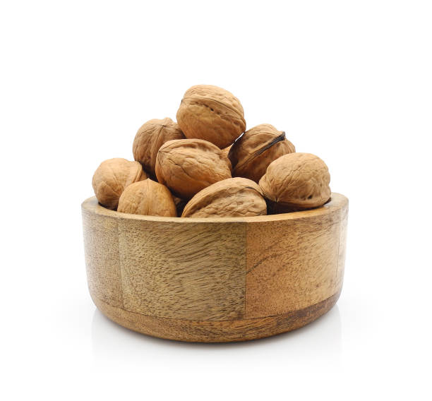 istock Walnuts in wooden bowl isolated on white 1488794414