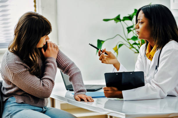 istock Young woman holding arm, explaining to doctor 1488795078