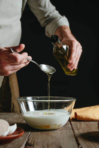 istock Unrecognizable man in an apron adding vegetable oil to a bowl 1488796373