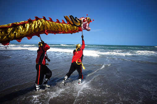 Yogyakarta, Indonesia, 23 June 2012: A number of residents of Chinese descent play Liong during the Peh Cun celebration at Parangtritis Beach, Bantul, Yogyakarta. This event was held in order to welcome the Chinese New Year.