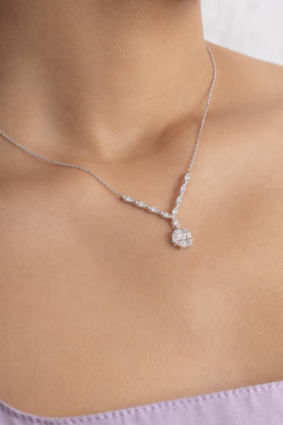 eine teure und bestickte halskette aus weißgold am hals der frau. - necklace jewelry diamond silver stock-fotos und bilder
