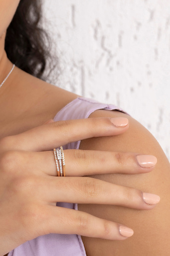 An expensive and embroidered ring made of white gold on the woman's finger. There are precious stones on the ring.