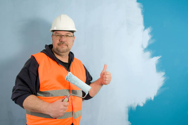 istock Painter at work. First layer of paint. On a dark wall, apply a light base coat of paint. 1488800166