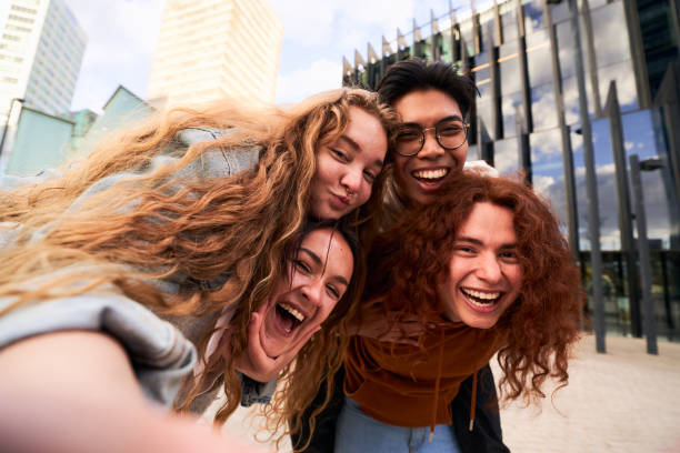 istock Group of student friends having fun outdoors taking a selfie looking at camera while doing piggyback 1488807012