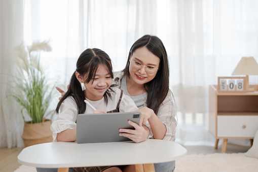 Asian family mother and daughter using the tablet in the home