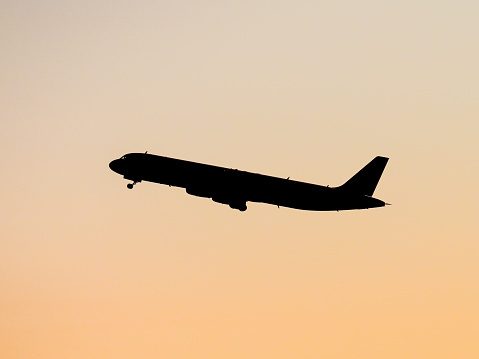 A Jetstar Airbus A321-231, registration VH-VWW, taking off from the south at Sydney Kingsford-Smith Airport and heading to Townsville as flight JQ912.  Her landing gear is still being retracted.  This image faces east and the rising sun.  This image was taken from the Botany side of the Cooks River in Kyeemagh, Sydney on a cold and windy morning on 7 May 2023.