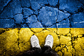 Flags of the Ukrainian flag were repeatedly exposed in cracks in the concrete floor. Ukraine and Russia. Double exposure of Ukraine-Russia war conceptual image.
