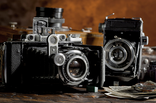 Vintage photo camera on an old background in a composition with photo accessories.