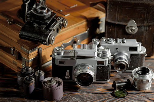 Vintage photo camera on an old background in a composition with photo accessories.