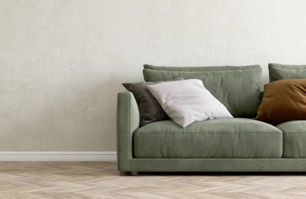 istock Modern, comfortable sage green suede leather sofa with black, gray cushion in sunlight on white abstract texture wall, brown parquet floor 1488812612