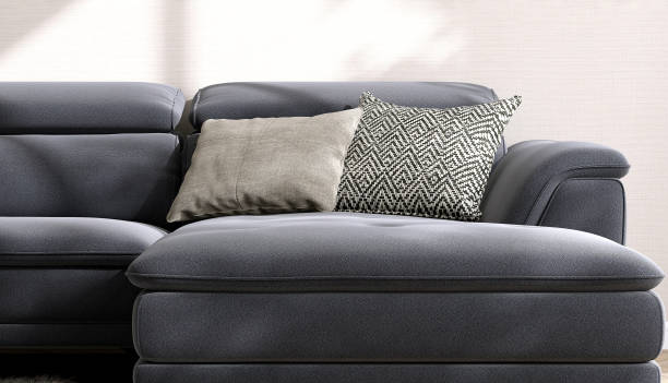 istock Close up modern, comfortable gray black leather sofa with woven cushion in sunlight on cream fabric texture wallpaper wall 1488812836
