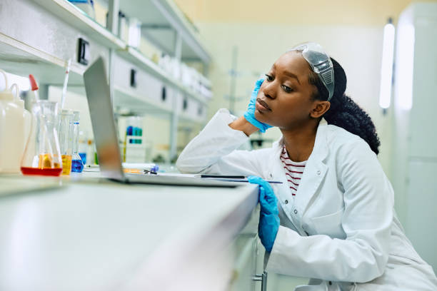 istock Pensive black scientist working on laptop during her research in a laboratory. 1488815693