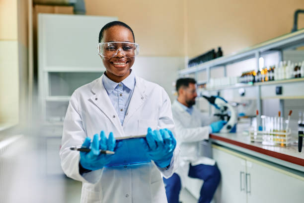 istock Happy black female scientist in a laboratory looking at camera. 1488815782