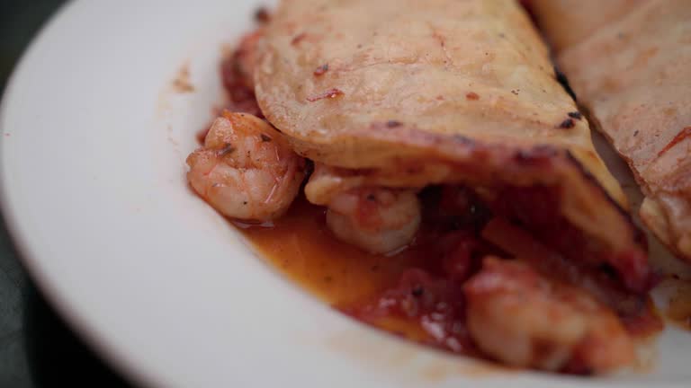 Handheld Shot of Saucy Shrimp Tacos Gobernador (