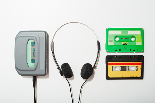 Old retro cassette tapes and a walkman stereo player. Vintage 80's music tapes and stereo player isolated on white background