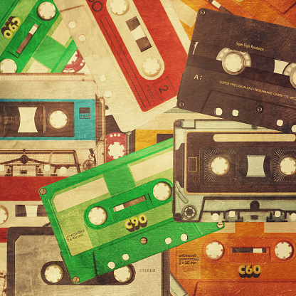 Background poster made with a group of old retro cassette tapes. Collecttion of various vintage 80's music tapes as a background