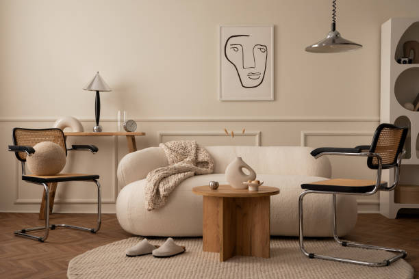 istock Creative composition of living room interior with mock up poster frame, white sofa, braided plaid, wooden coffee table, rattan chair, chrom lamp and personal silver accessories. Home decor. Template. 1488819267