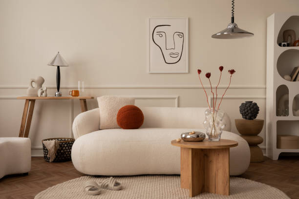 istock Creative composition of living room interior with mock up poster frame, white sofa, round pillow, wooden coffee table, stylish pouf, chrom lamp and personal silver accessories. Home decor. Template. 1488819314