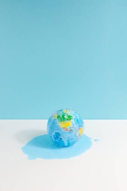 istock Global warming concept with the world globe melting on white and blue background. Vertical view 1488820534