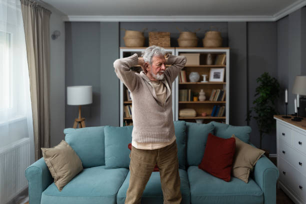 istock Sporty elderly guy practicing yoga indoors. Senior man doing stretching exercise at home. Active lifestyle and healthcare in any age. Old retired person light fitness training in living room 1488821948