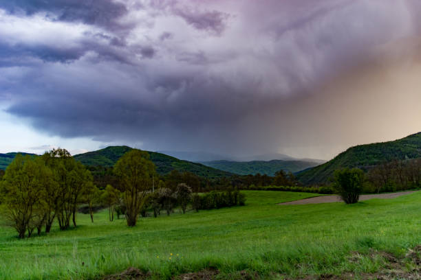 eine dramatisch große regenwolke kommt aus der ferne und bringt regen - valley storm thunderstorm mountain stock-fotos und bilder