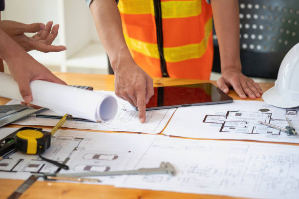 istock Asian engineers brainstorm and measure to document cost estimates and write floor plans for architectural and engineering designs for houses and buildings. 1488822249