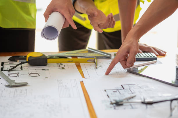 istock Asian engineers brainstorm and measure to document cost estimates and write floor plans for architectural and engineering designs for houses and buildings. 1488822270