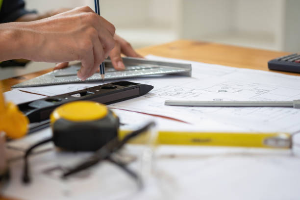 istock Asian engineers brainstorm and measure to document cost estimates and write floor plans for architectural and engineering designs for houses and buildings. 1488823287