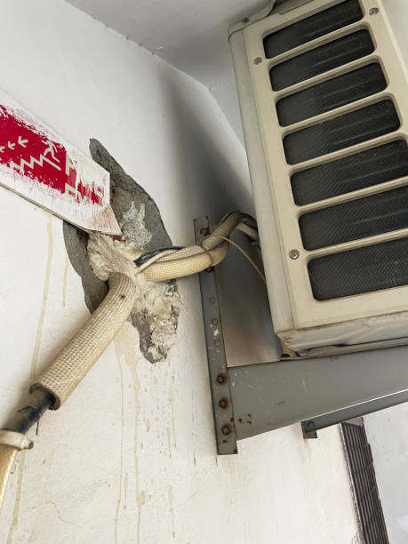 istock Close-up image of badly installed air conditioning extractor unit on apartment balcony wall, wires and cables, unsightly hole in wall, health and safety issue concept 1488823566