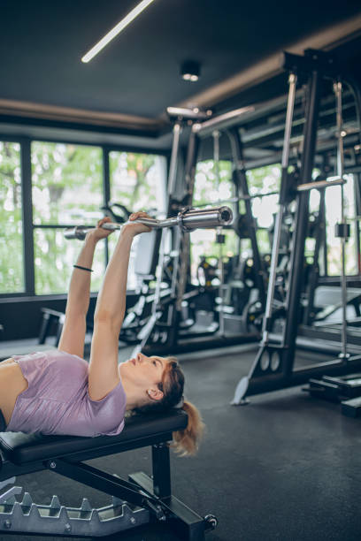 istock Young woman training in gym with barbell 1488823926