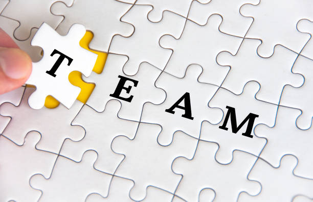 istock Team text on white jigsaw puzzle. Business and teamwork concept 1488824867