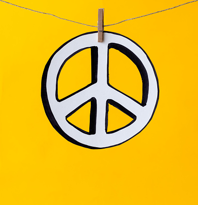 Freedom symbol hanging with a clothesline against a yellow background.