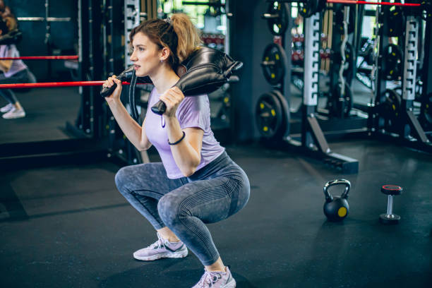 istock Young woman training in gym with shoulder weights 1488825835