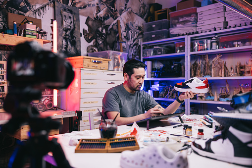 Surrounded by an array of tools and materials, a talented sneaker designer from Japan films himself, as he creates a personalized pair of sneakers, sharing his expertise with the world.
