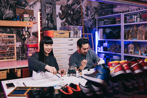 In a bustling studio filled with vibrant energy, two passionate Japanese sneaker artists 
collaborate on a new project, fueled by their shared love of innovative design.