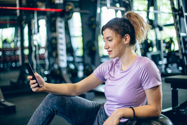 istock Young female athlete using smartphone in the gym 1488827541