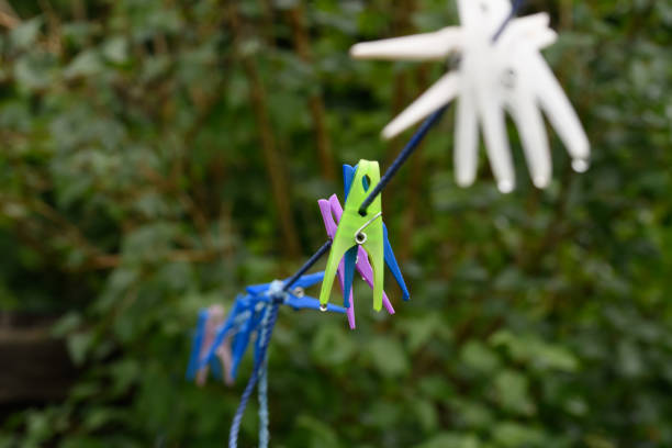 plastic clothespins in different colors for pinning wet clothes to a clothesline hanging in a sunny yard