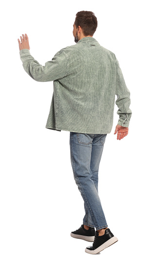 Man in stylish outfit walking on white background, back view