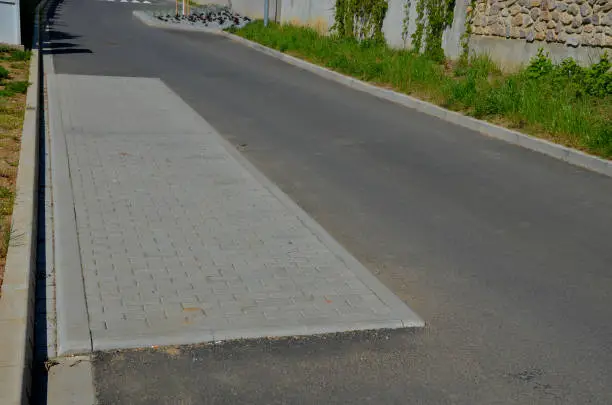 in the middle of the road leading to the residential area, the police and the traffic office installed a red plastic retarder. raised square made of rubber beveled on the sides, arrow, triagle, atropurpurea