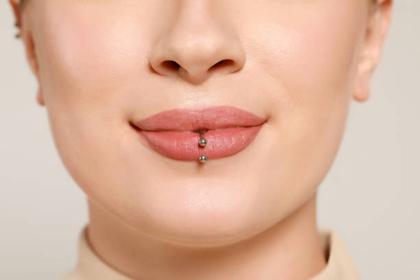 istock Young woman with lip piercing on white background, closeup 1488829867