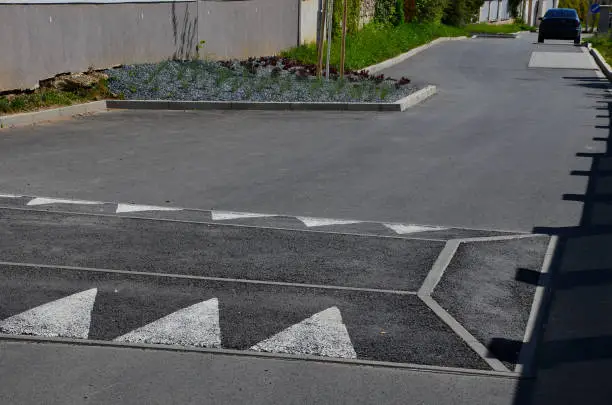 in the middle of the road leading to the residential area, the police and the traffic office installed a red plastic retarder. raised square made of rubber beveled on the sides, arrow, triagle, atropurpurea