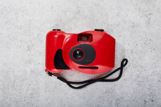 istock Red colored 35mm point and shoot film camera on concrete background 1488831954